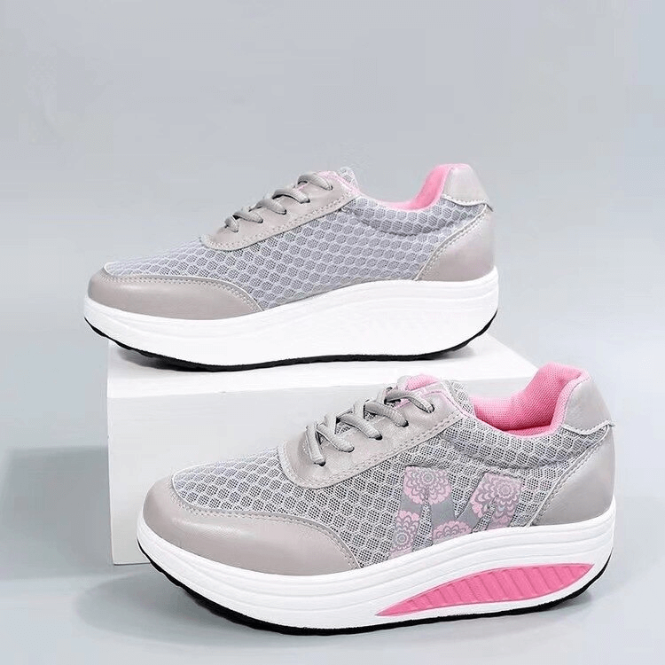 Gray and pink breathable mesh sneakers with thick sole, lace-up design, and stylish floral accents on a display box.